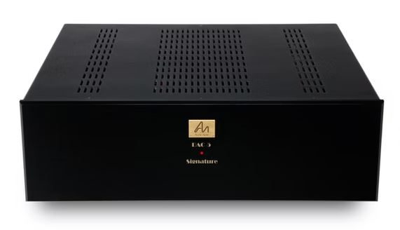 Schwarzer DAC mit belüftetem Design und goldfarbenem Logo auf der Vorderseite.