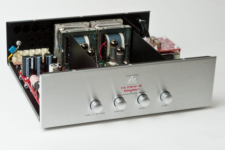 Silberner Verstärker mit Drehknöpfen und sichtbaren internen Komponenten.