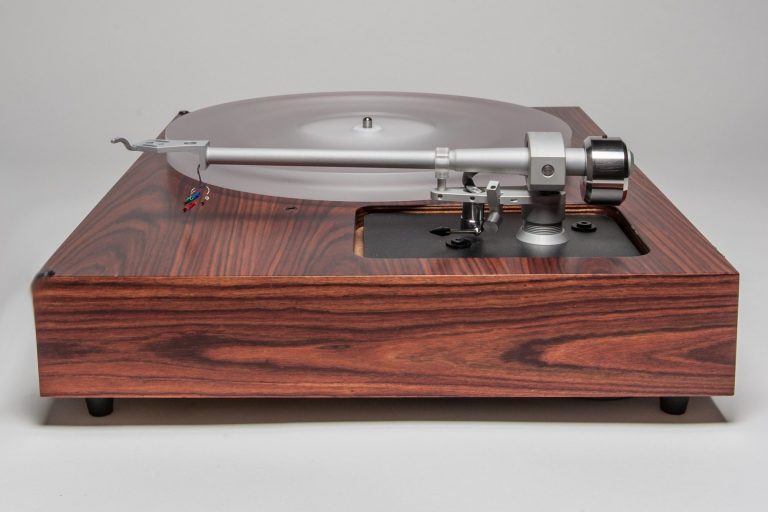Ein stilvoller Plattenspieler mit Holzgehäuse und transparenter Haube.