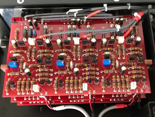 Detailreiche rote Leiterplatte mit zahlreichen elektrischen Komponenten und Anschlüssen.