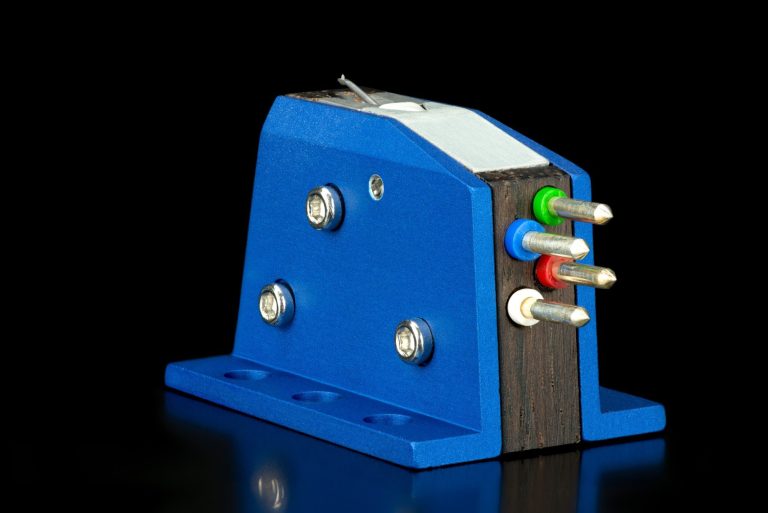 Audio Note MC-Tonabnehmer Blaue Audio Note MC-Tonabnehmer mit Anschlüssen in Rot, Grün und Weiß auf schwarzem Hintergrund.