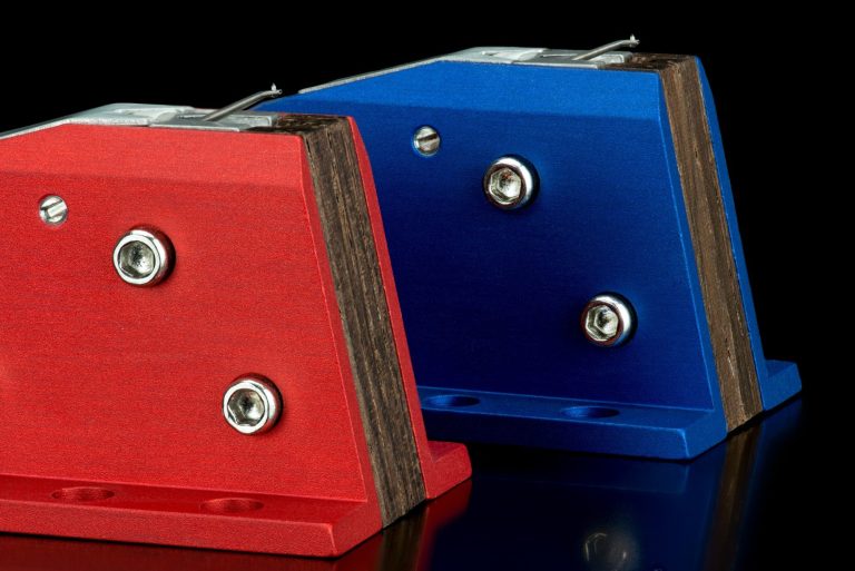 Rote und blaue Audio Note MC-Tonabnehmer mit silberne Schrauben auf schwarzem Hintergrund.