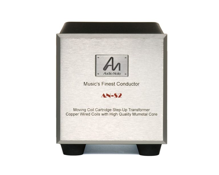 Ein rechteckiger, silberner MC-Step-up-Transformer mit schwarzem Gehäuse und Logo.